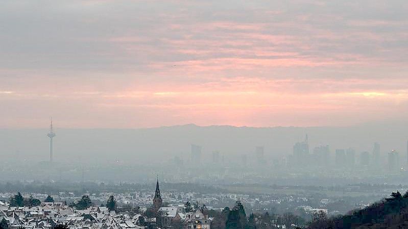 Dichter Hochnebel und Wolken bei Sonnenaufgang über Frankfurt am Main. Foto: Boris Roessler/dpa