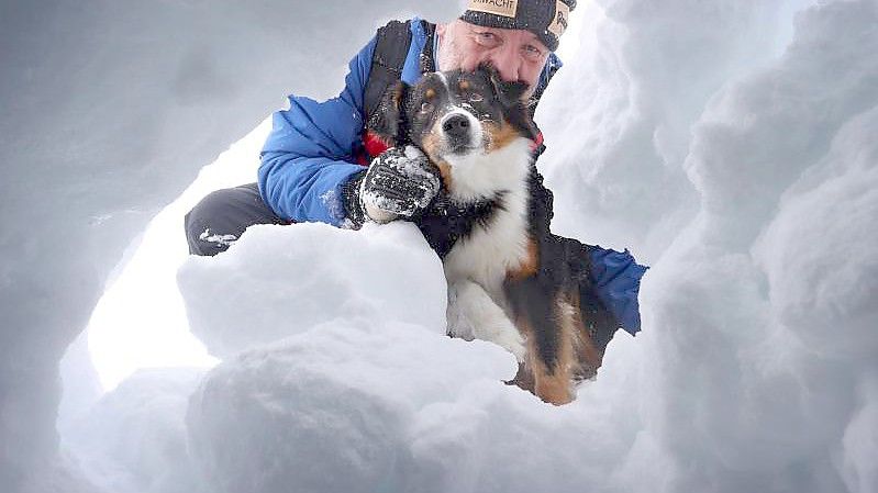 Der Hundeführer Dörg Stephan sucht mit seiner Lawinensuchhündin Amira nach einem Verschütteten. Foto: Karl-Josef Hildenbrand/dpa