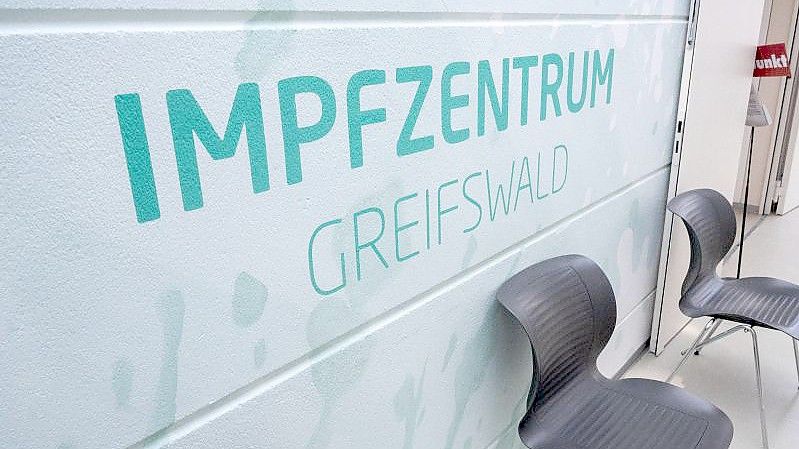 Ein Schriftzug "Impfzentrum" weist den Weg zum Corona-Impfstützpunkt des Landkreises Vorpommern-Greifswald. Foto: Stefan Sauer/dpa