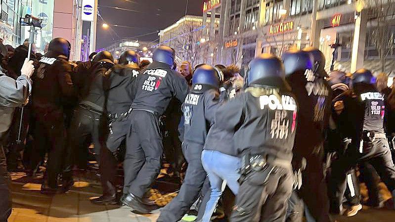 Teilnehmende einer Demonstration gegen die Corona-Maßnahmen und Polizisten stehen sich in der Innenstadt gegenüber. Foto: Thomas Schulz/dpa-Zentralbild/dpa