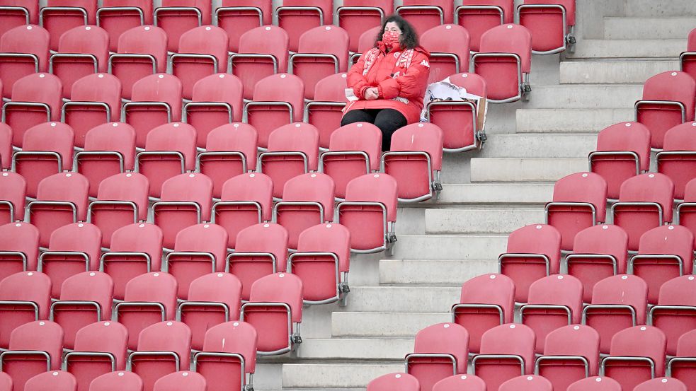Ein einziger Zuschauer sitzt auf der Tribüne eines Stadions. In Bayern könnte das bald wieder anders aussehen. Foto: DPA