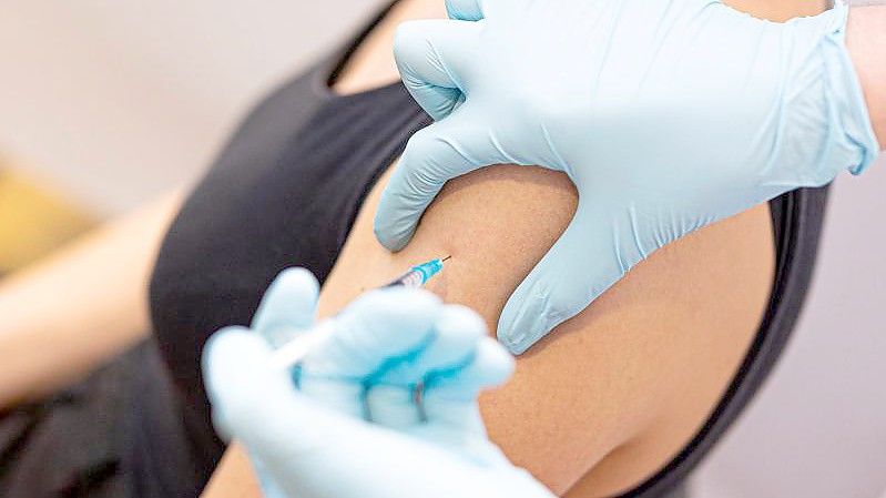 Eine Frau lässt sich gegen Covid-19 impfen. Foto: Moritz Frankenberg/dpa