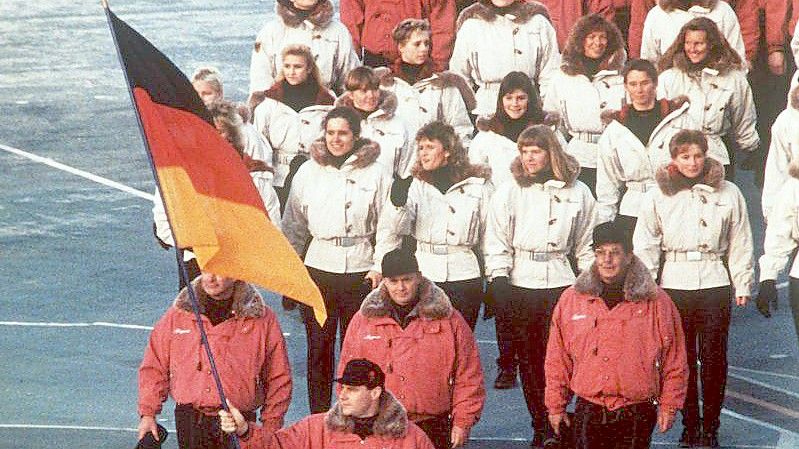 Hinter ihrem Fahnenträger zieht die deutsche Mannschaft 1992 in das Stadion von Albertville ein. Foto: Rolf Haid/dpa