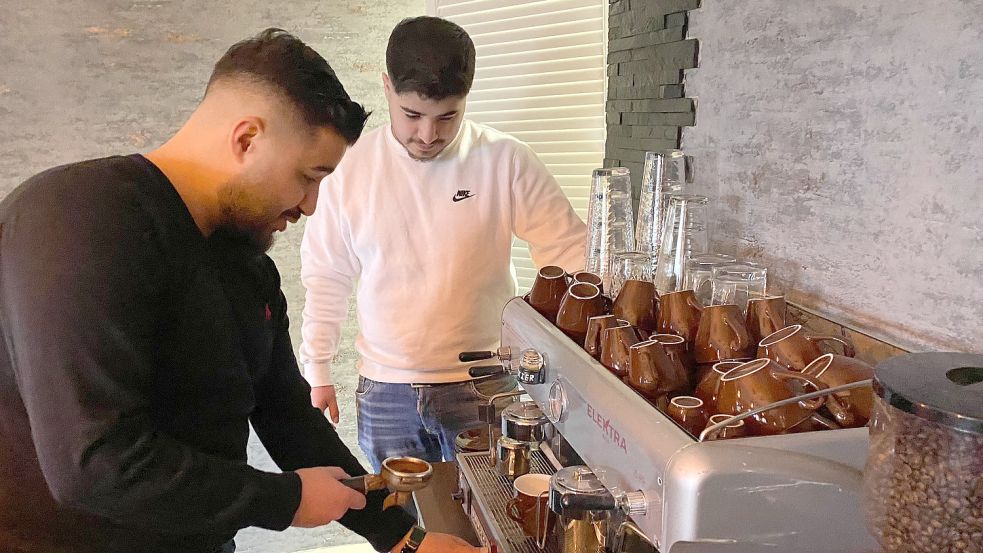 Der in der Gastronomie erfahrene Abdallah Boral gibt seinem Bruder Tipps im Umgang mit der Kaffeemaschine. Foto: Holger Janssen