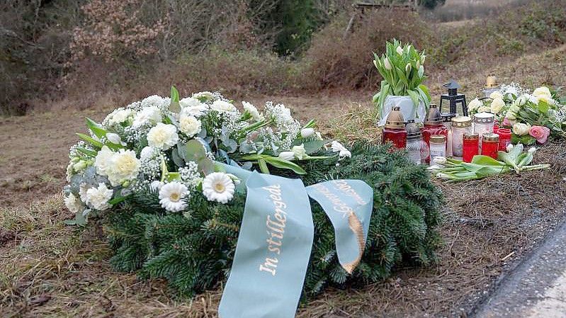 Ein Kranz, Blumen und Kerzen für die getötete Polizistin und ihren Kollegen. Foto: Harald Tittel/dpa