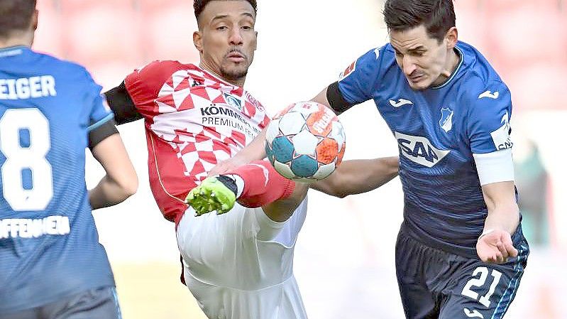 Der Mainzer Karim Onisiwo (M) kommt vor Hoffenheims Benjamin Hübner an den Ball. Foto: Torsten Silz/dpa