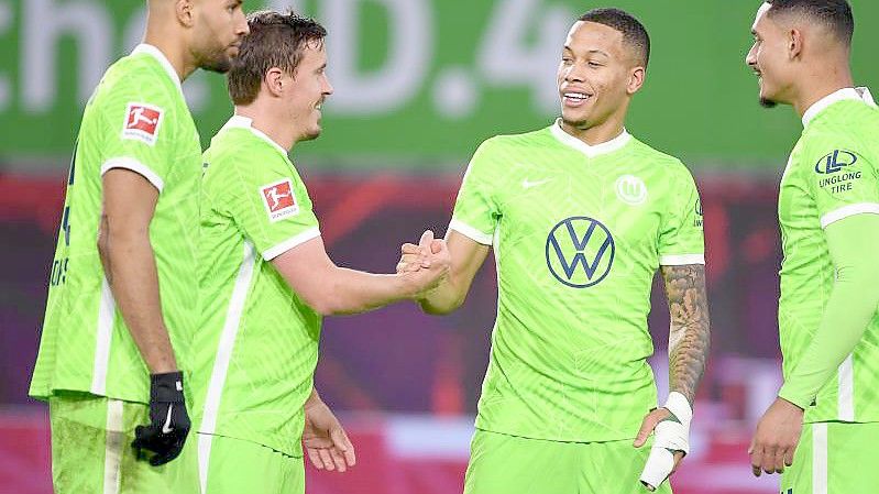 Wolfsburg-Neuzugang Max Kruse (2.v.l.) klatscht nach dem Treffer zum 2:1 mit Aster Vranckx ab. Foto: Swen Pförtner/dpa