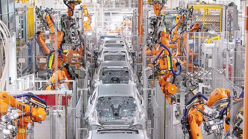 Roboter von ABB arbeiten an der Karosserie von verschiedenen BMW-Modellen im BMW-Stammwerk. Die Produktion der Industrie in Deutschland hat trotz eines Dämpfers zum Jahresende im Gesamtjahr 2021 zugelegt. Foto: Sven Hoppe/dpa