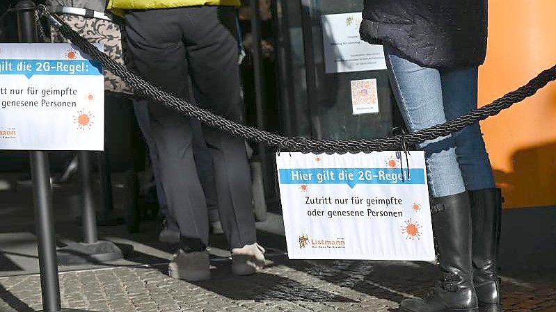 Vor einem Geschäft für Bastelbedarf in der Mainzer Innenstadt hängen Hinweisschilder mit der Aufschrift "Hier gilt die 2G-Regel. Foto: Arne Dedert/dpa