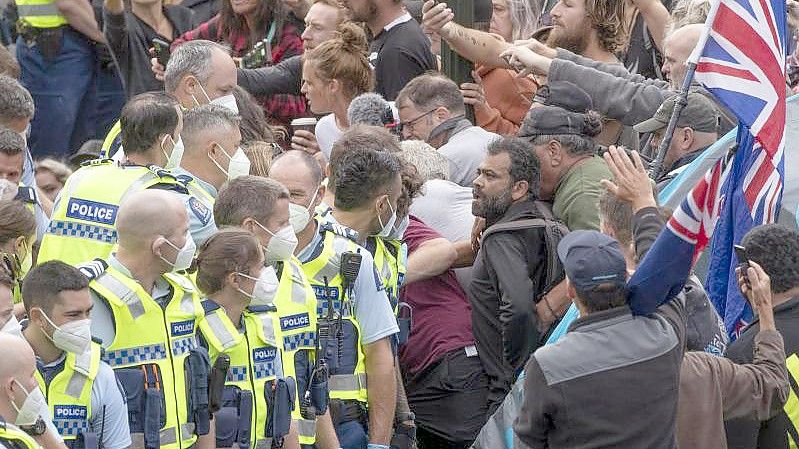 Die Polizei nimmt Menschen fest, die vor dem Parlament im neuseeländischen Wellington gegen eine Coronavirus-Impfpflicht protestieren. Foto: Mark Mitchell/NZME via AP/dpa