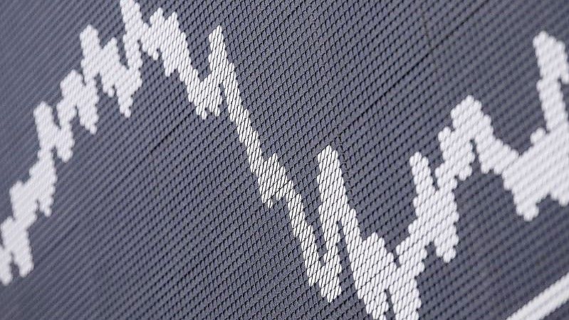 Die DAX-Kurve im Handelssaal der Deutschen Börse in Frankfurt. Viele Sparer in Deutschland entdecken dem Fondsverband BVI zufolge in Zeiten von Zinsflaute und gestiegener Inflation die Wertpapieranlage für sich. Foto: Boris Roessler/dpa