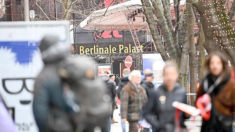 Festivalbesucher gehen über den Potsdamer Platz in Berlin. Foto: Britta Pedersen/dpa-Zentralbild/dpa