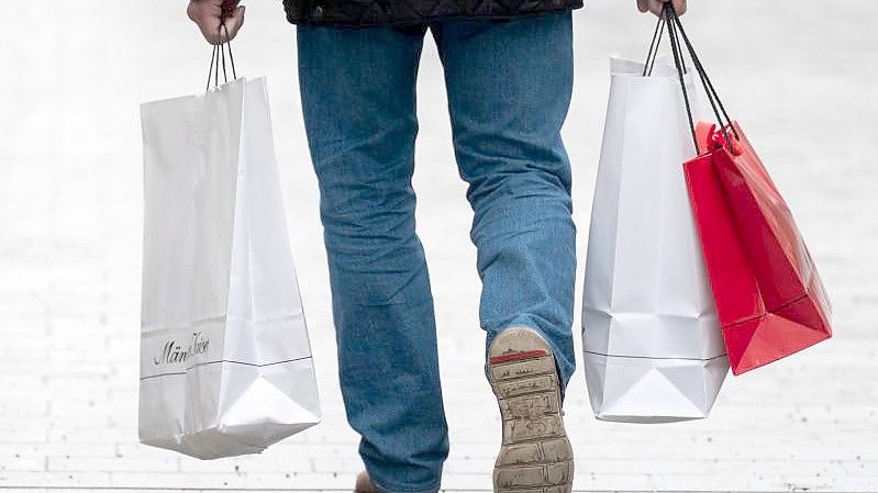 Ein Mann läuft mit Einkaufstaschen durch die Innenstadt von Hannover. Jeder Einwohner der Europäischen Union konsumiert pro Jahr im Durchschnitt knapp 15 Kilogramm an Bekleidung und weiteren Textilien. Foto: Julian Stratenschulte/dpa