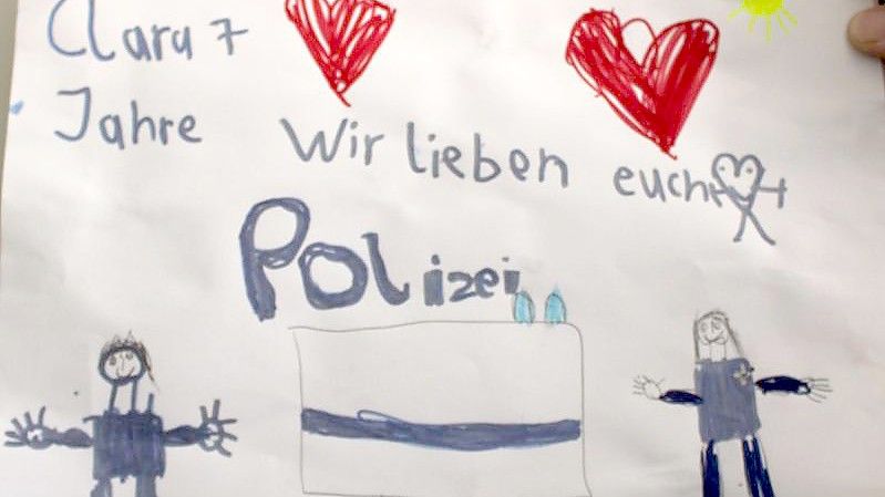 Eine von der Polizei Rheinland-Pfalz zur Verfügung gestellte Kinderzeichnung erinnert an die beiden in Kusel getöteten Polizisten. Foto: -/Polizei Rheinland-Pfalz/dpa