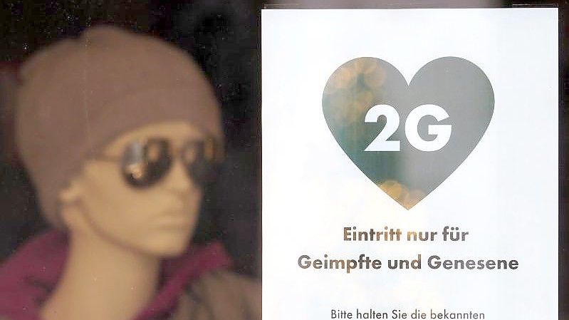 Ein Schild weist die Kunden eines Modegeschäfts in Potsdam auf die 2G-Regel hin. Foto: Soeren Stache/dpa-Zentralbild/dpa