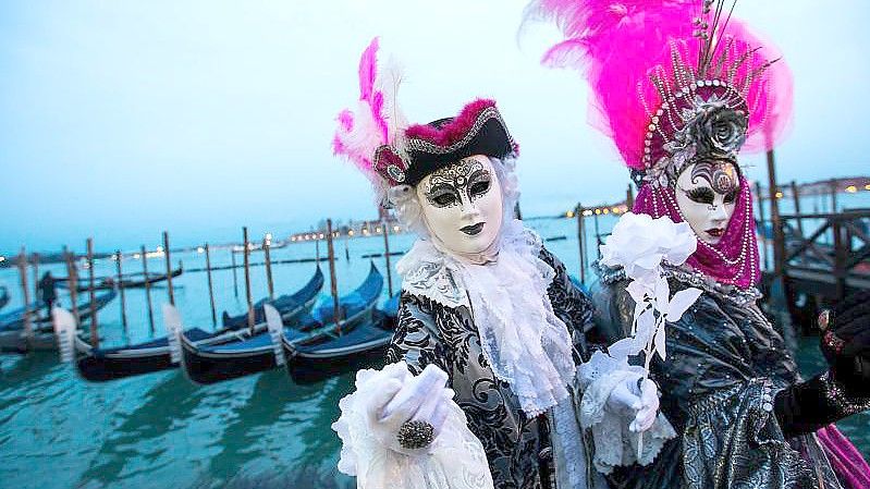 Kostümierte Menschen feiern Karneval in Venedig - in diesem Jahr hybrid. Foto: Jin Yu/XinHua/dpa/Archiv