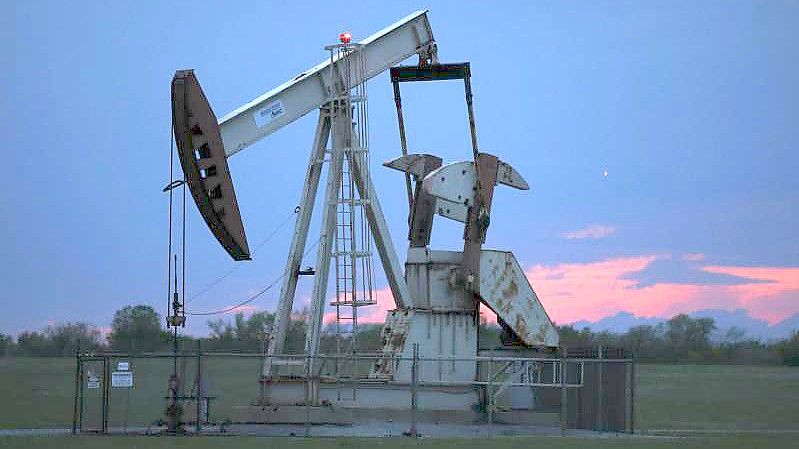 Ein Pumpe arbeitet bei Sonnenuntergang in einem Ölfeld. Der Höhenflug der Ölpreise hält an. Am Montagmorgen markierten die beiden wichtigsten Erdölsorten abermals mehrjährige Höchststände. Foto: Sue Ogrocki/AP/dpa