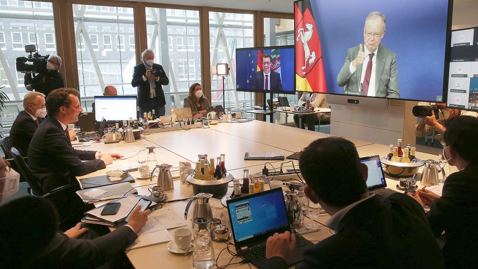 Hendrik Wüst (CDU, l.), Ministerpräsident von Nordrhein-Westfalen, eröffnet in der Landesvertretung in Berlin die Online-Ministerpräsidentenkonferenz und begrüßt Stephan Weil (SPD), Ministerpräsident in Niedersachsen, auf dem Bildschirm. Foto: Wolfgang Kumm/dpa