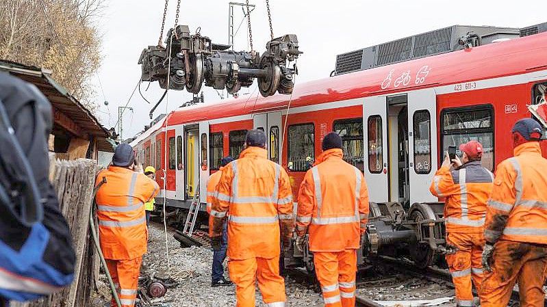 Aufräumarbeiten nach dem S-Bahn-Unfall: Das entgleiste Drehgestell hängt am Haken eines Krans. Foto: Matthias Balk/dpa