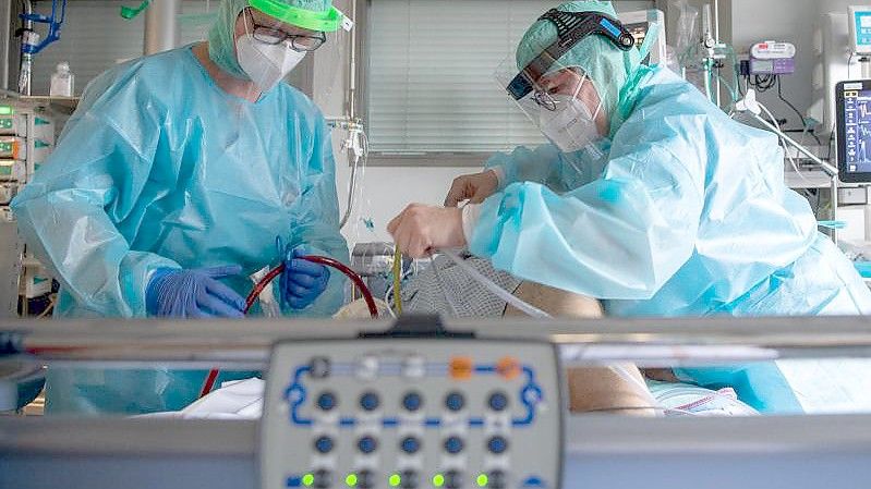 Intensiv-Pflegekräfte versorgen einen schwer an Corona erkrankten Patienten auf der Intensivstation des Klinikums in Fulda. Foto: Boris Roessler/dpa
