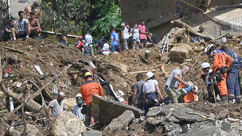 Rettungskräfte und Anwohner suchen nach Opfern in einem von Erdrutschen betroffenen Gebiet in Petropolis. Foto: Andre Borges/dpa