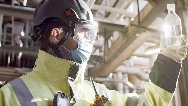 Ein Mitarbeiter von BP begutachtet eine Produktprobe des fertigen Biokerosin-Gemischs. Foto: BP Europa SE/dpa