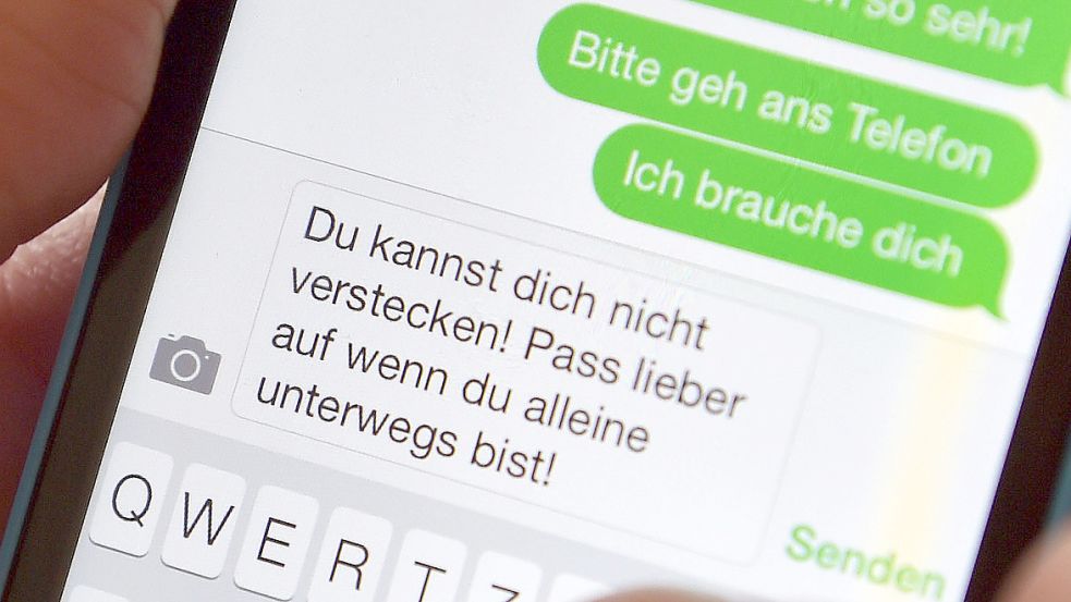 Ein Mann schreibt eine bedrohende SMS. Foto: DPA