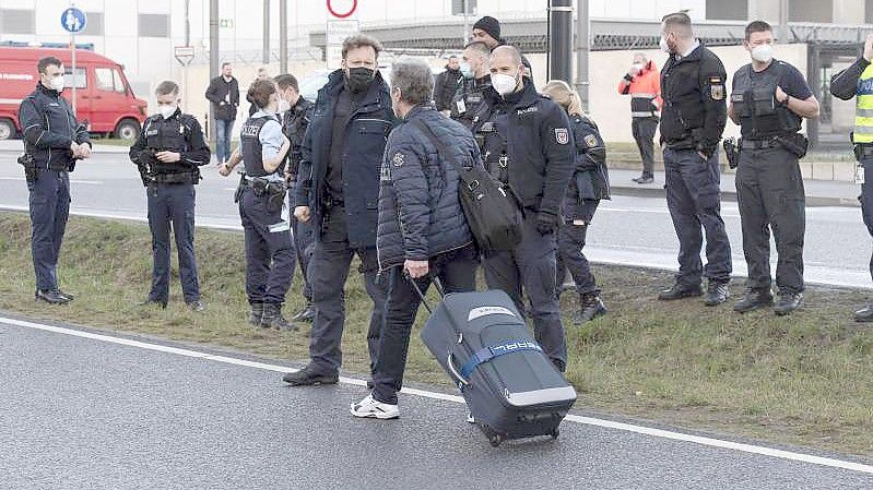 Klimaschutz-Aktivisten der Initiative "Aufstand der letzten Generation" blockieren eine Zufahrt zum Hauptstadt-Flughafen BER. Foto: Paul Zinken/dpa