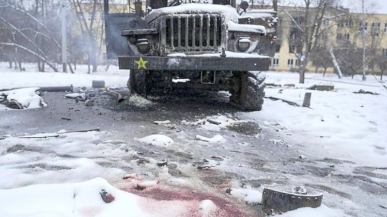Blut ist im Schnee neben einem zerstörten russischen Militärfahrzeug am Stadtrand von Charkiw zu sehen. Foto: Vadim Ghirda/AP/dpa