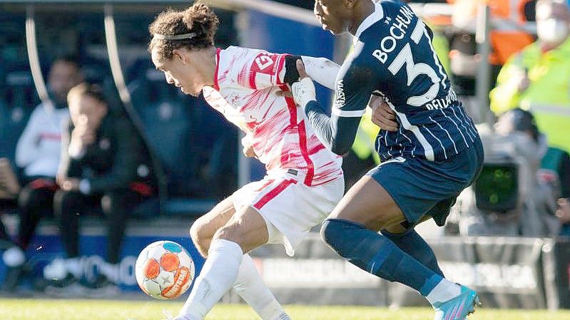 Der Leipziger Yussuf Poulsen (l) schirmt den Ball gegen Armel Bella Kotchap ab. Foto: Bernd Thissen/dpa