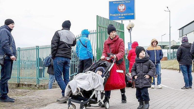 Eine ukrainische Familie geht durch den Grenzübergang nach Polen. Foto: Dominika Zarzycka/SOPA Images via ZUMA Press Wire/dpa