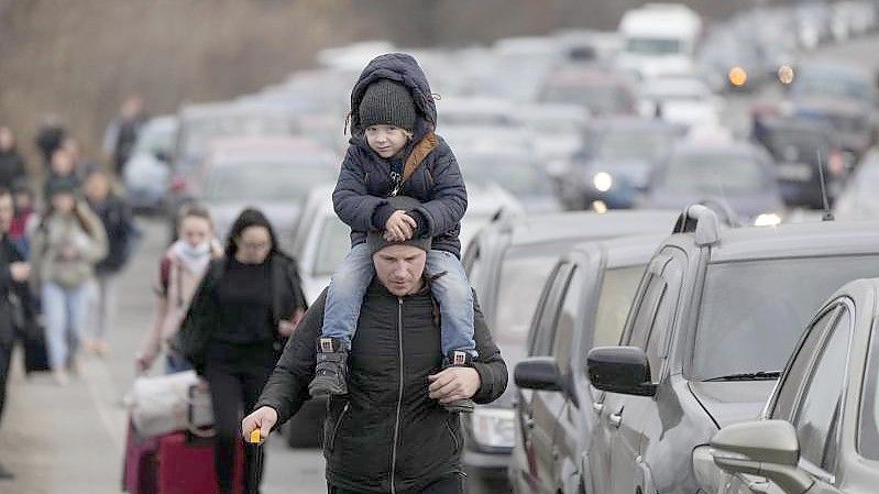 Aus der Ukraine geflüchtete Menschen am Grenzübergang Mayaky-Udobne. Wegen des russischen Angriffs auf ihre Heimat sind Hunderttausende auf der Flucht. Foto: Sergei Grits/AP/dpa