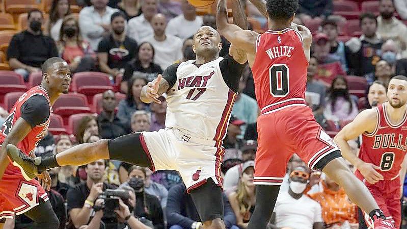 P.J. Tucker (M, l) von Miami Heat und Coby White von Chicago Bulls kämpfen in der ersten Halbzeit um dem Ball. Foto: Marta Lavandier/AP/dpa