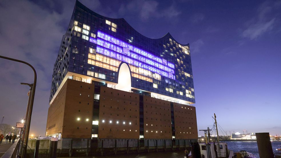 Einige Fenster in der Fassade der Elbphilharmonie sind am Abend in den Farben der Ukraine beleuchtet. Foto: DPA