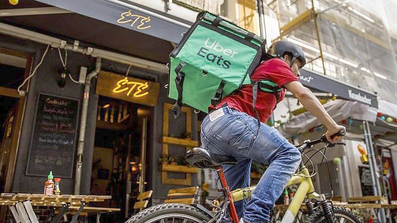 Ein Fahrer für Uber Eats unterwegs in Berlin Friedrichshain. Foto: Carsten Koall/dpa