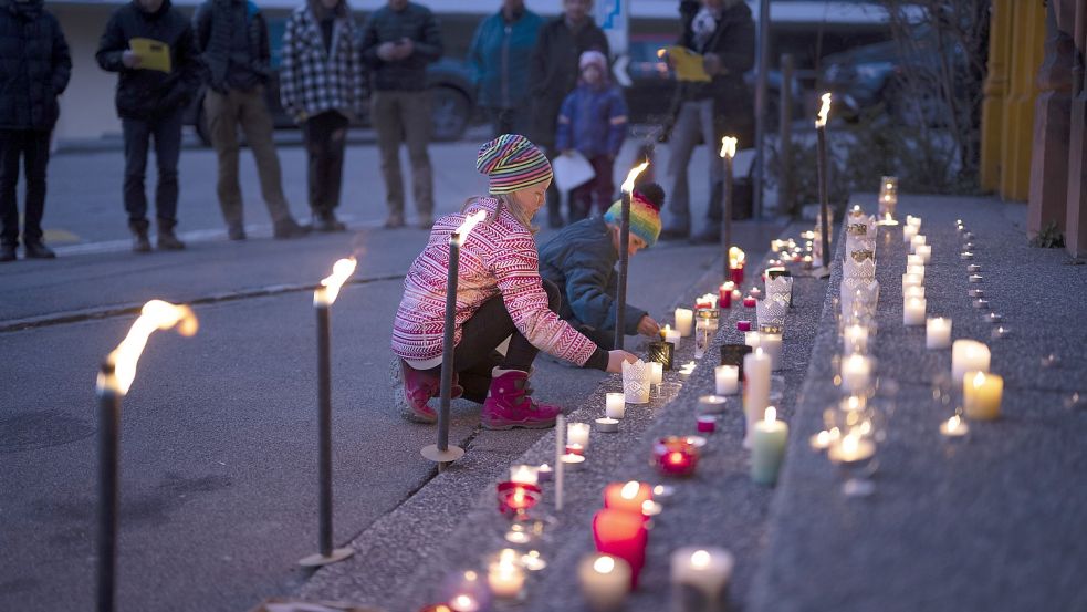 Kinder zünden auf den Stufen zu einer Kirche Kerzen an: Der Ukraine-Krieg wirft auch bei den Jüngsten im Kreis viele Fragen auf. Foto: Gian Ehrenzeller/DPA