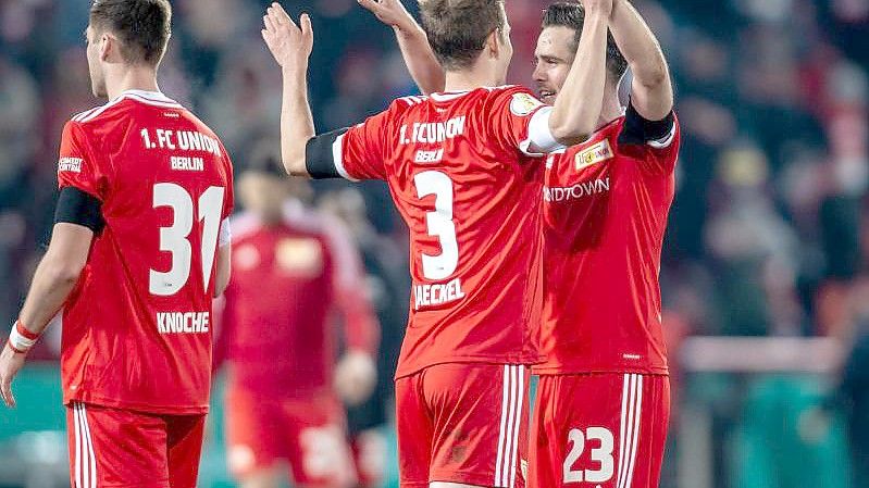 Berlins Niko Gießelmann (r) klatscht sich nach dem Sieg mit Teamkollege Paul Jaeckel (M) ab. Foto: Andreas Gora/dpa