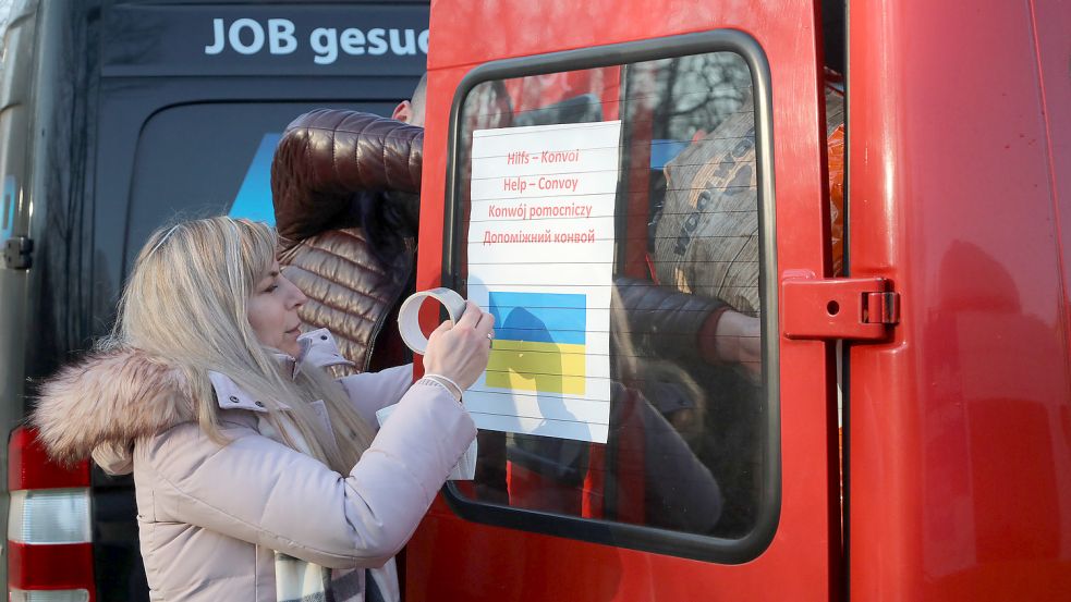 Letzte Vorbereitungen: Marina Pawlowski befestigt ein Schild mit der Aufschrift „Hilfs-Konvoi“ an einem Fahrzeug. Foto: Romuald Banik