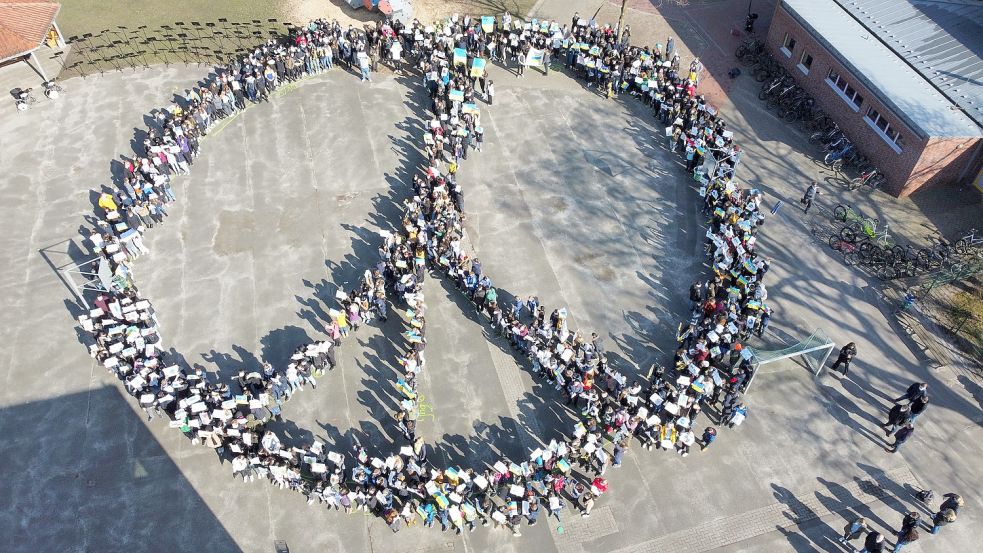 Zum Friedenszeichen stellten sich die Realschüler am Freitag auf ihrem Schulhof auf. Foto: Günter van Lessen