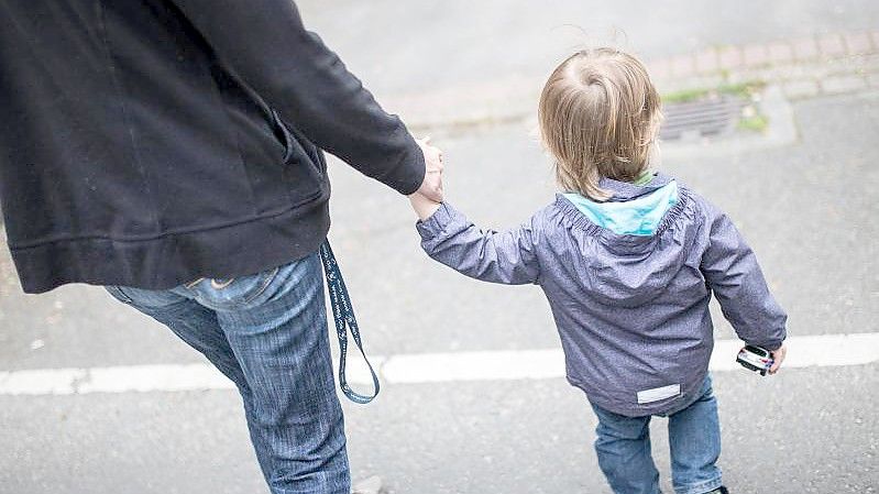 Eine Mutter hält ihren Sohn an der Hand. Foto: picture alliance / Marcel Kusch/dpa