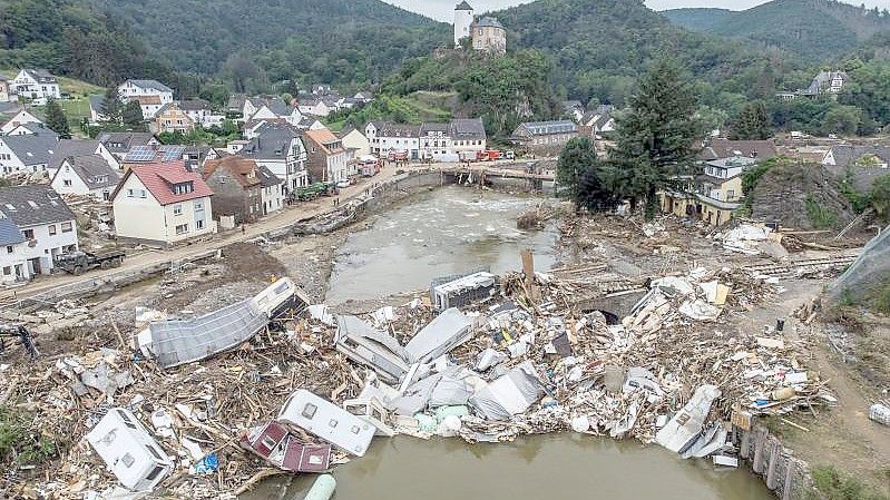 Meterhoch türmen sich im Juli 2021 Wohnwagen, Gastanks, Bäume und Schrott an einer Brücke über der Ahr in Altenahr. Foto: Boris Roessler/dpa