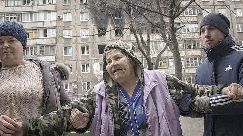 Im Hintergrund ein von Granaten getroffenes Haus. Die Lage in der eingekesselten Stadt Mariupol spitzt sich immer weiter zu. Separatisten sollen bis auf abermals vorgerückt sein. Foto: Evgeniy Maloletka/AP/dpa