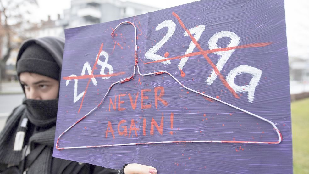 Eine Frau hält ein Plakat, mit dem sie die Abschaffung des umstrittenen Abtreibungsparagrafen 219a fordert. Zu sehen ist ebenfalls ein blutiger Kleiderbügel. Sie werden teilweise für illegale Abtreibungen benutzt. Foto: DPA
