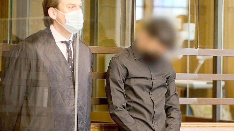 Der 22-jährige Angeklagte (r) steht zum Prozessauftakt neben seinem Anwalt im Landgericht Berlin. Foto: Annette Riedl/dpa