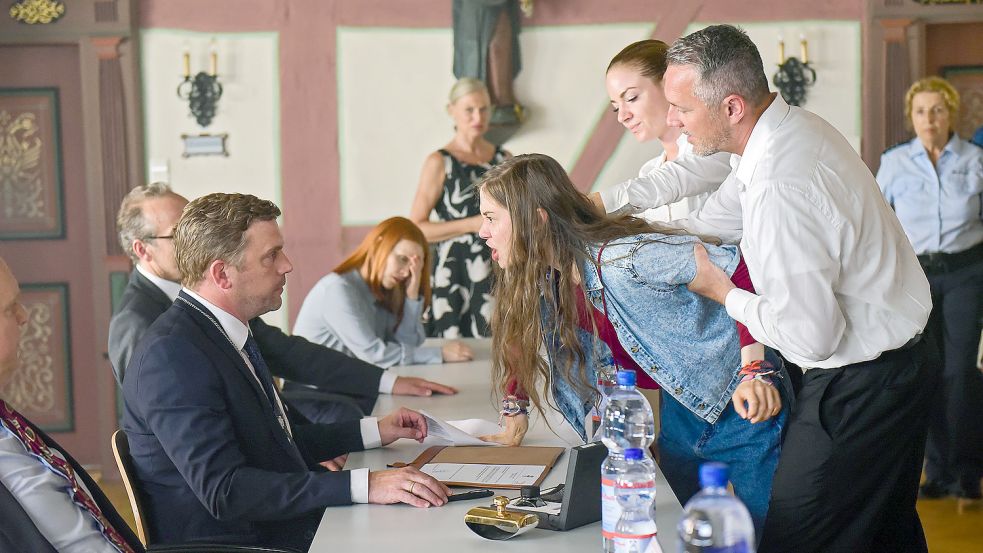 In einer Gemeinderatssitzung stellt sich Ava (Hannah Schiller) offen gegen ihren Vater Martin (Sebastian Bezzel, links), den Bürgermeister. Sie will verhindern, dass er der Firma PureAqua Zugriffsrechte aufs Grundwasser der Gemeinde gibt. Foto: SWR Presse