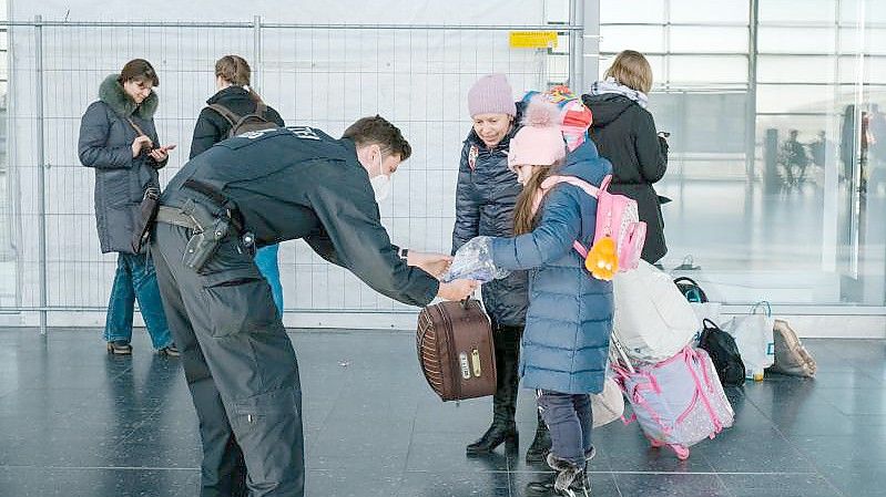 Ein Polizist verteilt im niedersächsischen Laatzen Schokolade an ein aus der Ukraine geflüchtetes Mädchen. Foto: Ole Spata/dpa