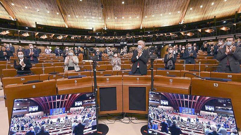 Mitglieder der politischen Delegationen der Parlamentarischen Versammlung des Europarates applaudieren nach einer Schweigeminute für die Opfer der russischen Invasion in die Ukraine. Foto: Frederick Florin/AFP/dpa