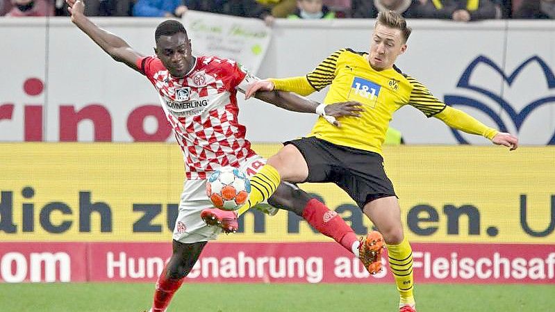 Der Mainzer Moussa Niakhate (l) und Dortmunds Felix Passlack kämpfen um den Ball. Foto: Torsten Silz/dpa