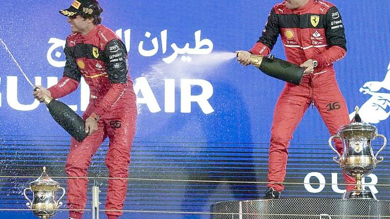 Charles Leclerc (r) feiert auf dem Podium mit seinem Teamkollegen Carlos Sainz. Foto: Hassan Ammar/AP/dpa