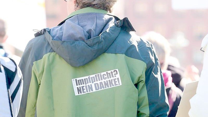 „Impfpflicht? Nein Danke!“ steht auf dem Rücken eines Demonstranten auf dem Potsdamer Platz in Berlin. Foto: Annette Riedl/dpa